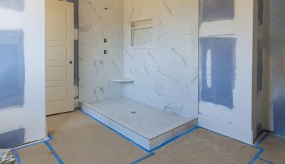 A bathroom being remodeled by a construction company in Brampton, with blue and white tape.